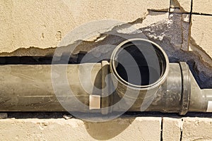 Installation of sewer pipes in a bathroom of an apartment interior during renovation works. Gray plastic drain pipe for used water