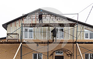 Installation of siding on the walls of the house