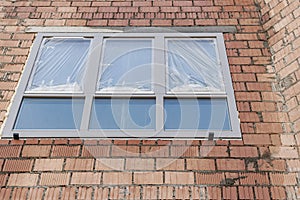 Installation of a window in a brick building. Industrial engineering. Darkening and installation of a window opening using