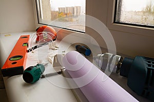 Installation of a window roller with a holder. Installation tool. Screwdrivers, drill, level, roller shutter and fasteners.