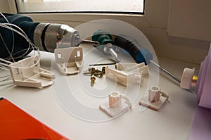 Installation of a window roller with a holder. Installation tool. Screwdrivers, drill, level, roller shutter and fasteners.