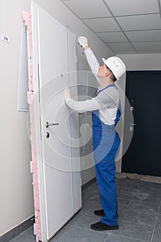 Installation wizard, measures the height of the door with a tape measure, before replacing it
