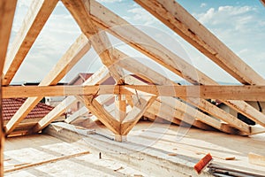 Installation of wooden beams at house construction site. Building details with wood, timber and iron holders