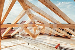 Installation of wooden beams at house construction site. Building details with wood, timber and iron holders photo