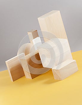 Installation of wooden geometric shapes on a light gray-yellow background