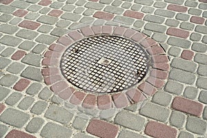 manhole in colored paving slabs