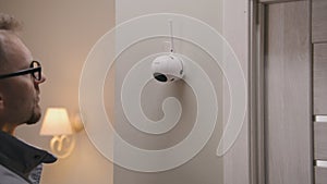 Installer puts security camera on wall mount