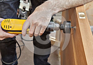 Installer to drill hole under door lock with handle, close-up.