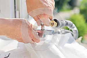 Installing an air conditioner in an apartment office, close-up of an technician hands