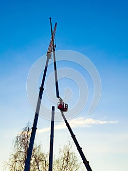 Installing the antenna on a blue sky background. Worker connects two metal pipes