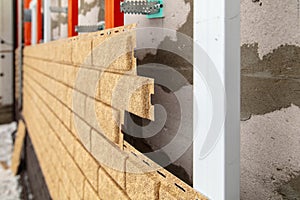 Installing brick siding on the wall of the house