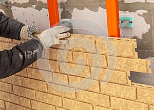 Installing brick siding on the wall of the house