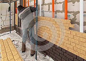 Installing brick siding on the wall of the house