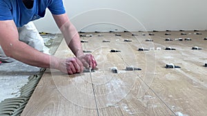 Installing ceramic floor tiles. Professional builder worker installing on floor a ceramic tile at repair renovation work 2