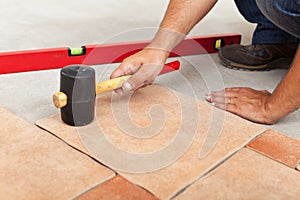 Installing ceramic flooring - fitting a tile photo