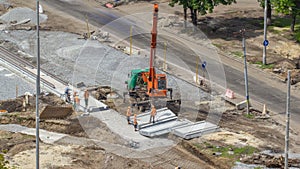 Installing concrete plates by crane at road construction site timelapse.