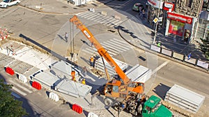 Installing concrete plates by crane at road construction site timelapse.