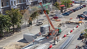 Installing concrete plates by crane at road construction site timelapse.