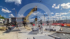 Installing concrete plates by crane at road construction site timelapse.