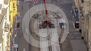 Installing concrete plates by crane at road construction site timelapse.