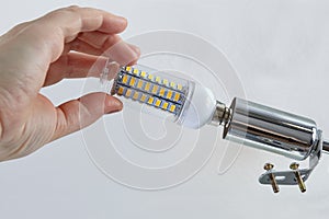 Installing an energy-efficient LED lamp in ceiling light.