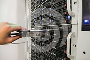 Installing a hard disk in the server room of the data center. Replacing the hard drive close-up.