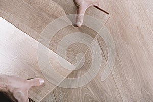 Installing laminate flooring in a room or office. Wooden parquet boards in the hands of a worker. Construction and