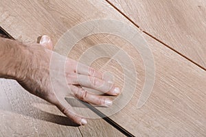 Installing laminate flooring in a room or office. Wooden parquet boards in the hands of a worker. Construction and