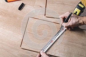 Installing laminate flooring in a room or office. Wooden parquet boards and tools. Construction and decorative works for