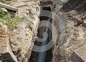 Installing sewer pipe in the ground trench. House sewer drain pipe installation