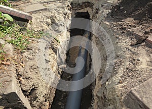 Installing sewer pipe in the ground trench. House sewer drain pipe installation photo