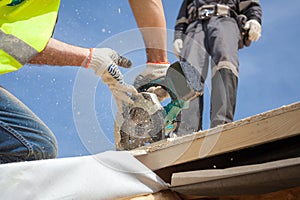 Installing a skylight. Construction Builder Worker use Circular Saw to Cut a Roof Opening for window.