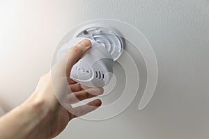 installing smoke detector on the room ceiling photo