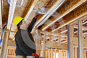 Installing a spotlight in the room on wooden beamed ceiling