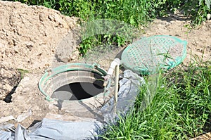 Installing water borehole drilling with plastic manhole cover. Water well, water borehole under construction