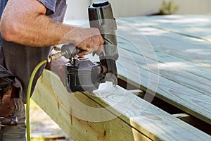 Installing Wood on deck, patio construction man using pneumatic gun