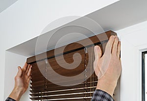 Installing wooden blinds.