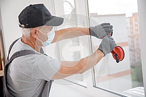 Installs plastic upvc windows and doors worker in medical mask