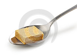 Instant chicken broth cube in a spoon