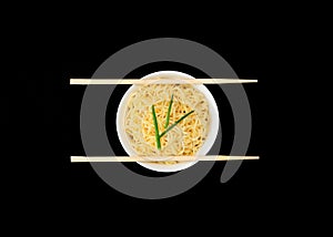 Instant Chinese curly noodles in white bowl with wood sticks on black background. Selective focus. Asian food concept