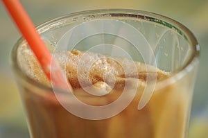 Instant coffe in a glass with a red straw photo