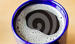 Instant coffee in a blue mug on an orange light background
