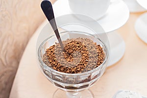 Instant coffee in a glass bowl on a background of white coffee cups