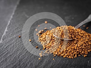 Instant coffee granules on a dark stone background