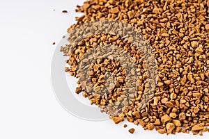 Instant coffee granules on a white acrylic background