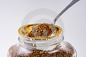 Instant coffee granules on a white acrylic background