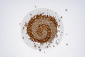 Instant coffee granules on a white acrylic background