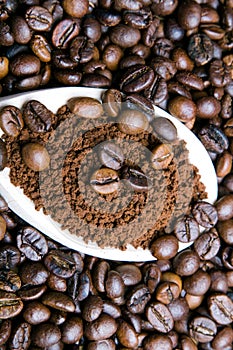 Instant coffee in spoon on coffee beans