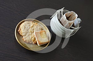 Instant freshly brewed cup of coffee,Drip bag fresh coffee served with cream crackers .  copy space for text insertion