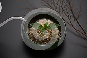 Instant noodles in a green ceramic bowl